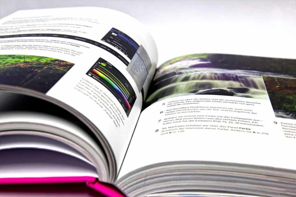 A picture of an open book showing text and photos used in the article, IAP Book Editing Course, with the-bare-foot-affiliate.com in black at the bottom of the photo.