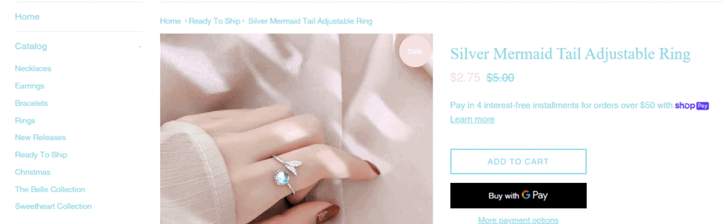 Screenshot of the catalogue list and a a photo of a Silver Mermaid Tail adjustable ring for $5.00 used in the article, Is Belle and Bling $5 Jewelry a Scam