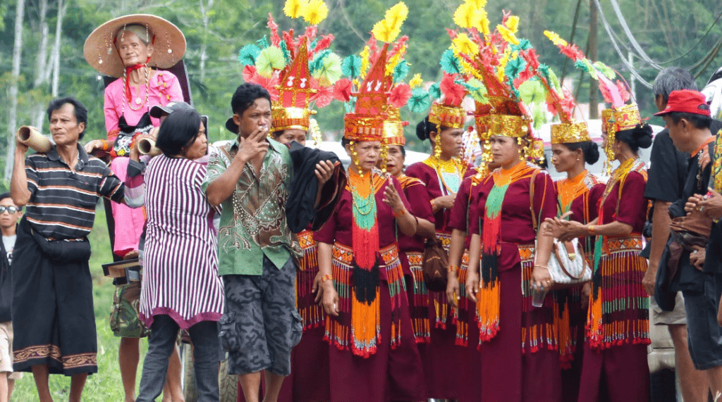 Women in tradititionl costume at a burial ceremony in Tana Toraja with a Tau Tau (wood statue) of the deceased. Used in the article Death and Dying in Torajan Culture