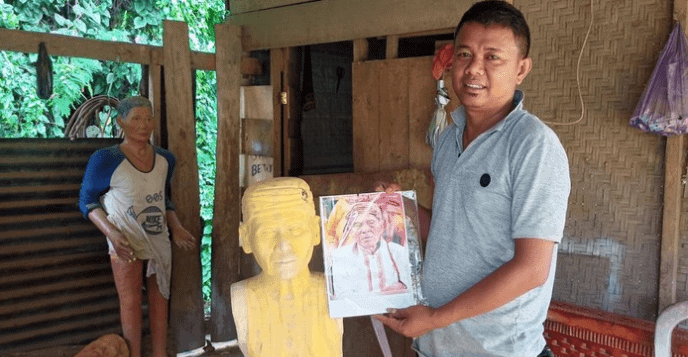 A Taau Tau sculptor in Tana Toraja Indonesia showing a part finished sculpting portrait of the deceased person. Used in the article death and dying in Torajan culture 