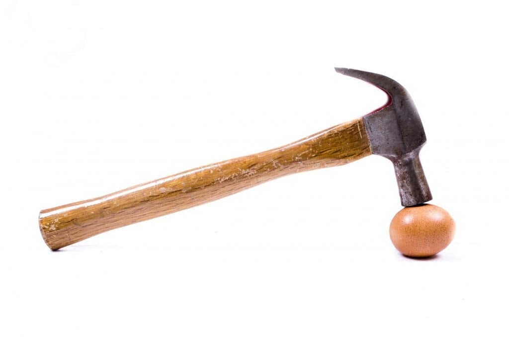 Cracking an egg with a hammer. Used in the article Can you open a Bakery without experience.
