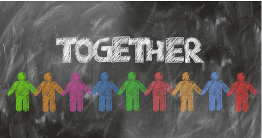 A blackboard with the word "Together" in white chalk and various colored figure drawn underneath holding hands.  Used in the article,  How to Build a Thriving Wellness Coaching Business From Scratch.